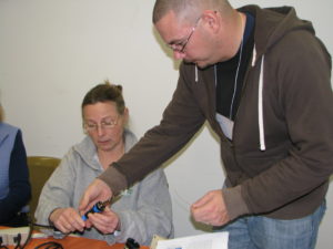 Jason shows an educator how to use a soldering iron during a SeaPerch Focus Workshop.